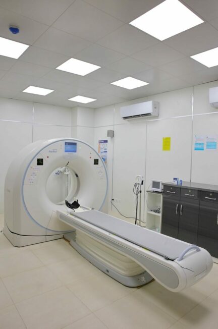 examens médicaux / High-tech CT scanner in a bright, well-equipped hospital room for medical diagnostics.