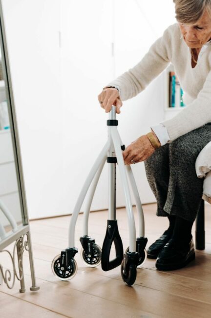 médecin MPR / Elderly woman making adjustments to her rollator walker at home.