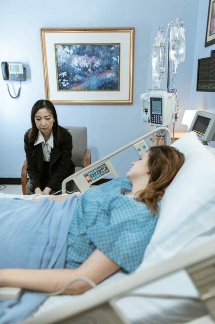 la santé des femmes / A hospital room showing a patient in bed and a visitor sitting beside her.